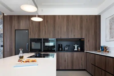 a kitchen with a white counter and wooden walls at Villa Zenora in Litsárdha