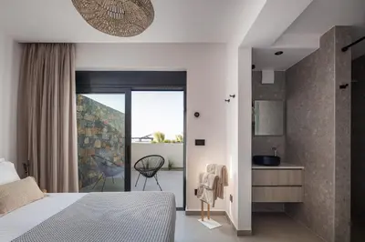 a bedroom with a bed and a bathroom at Villa Zenora in Litsárdha