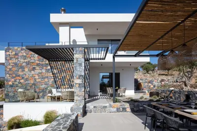 a modern house with a stone wall at Villa Zenora in Litsárdha