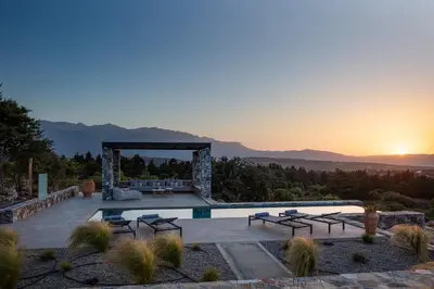 a view of a pool with a sunset in the background at Villa Zenora in Litsárdha