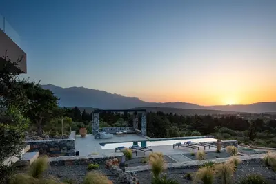 a view of a building with a sunset in the background at Villa Zenora in Litsárdha