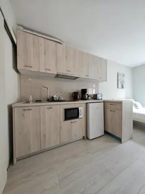 a kitchen with wooden cabinets and a white appliance at Casa di Rosa in Chania Town