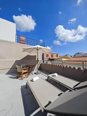 a patio with a table and an umbrella on a roof at Casa di Rosa in Chania Town