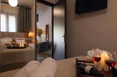 a room with a bed and a table with wine glasses at Dreamscape Residences - Zephi Suite in Chania Town