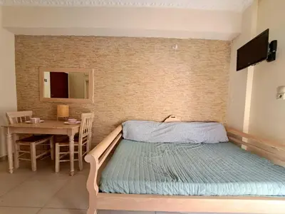 a small bedroom with a bed and a table at Center studio 25 in Chania Town