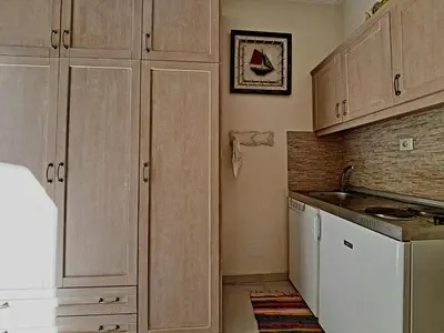 a kitchen with wooden cabinets and a white refrigerator at Center studio 25 in Chania Town