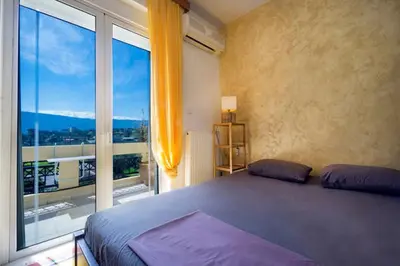 a bedroom with a bed and a large window at Penthhouse next to the beach in Souda