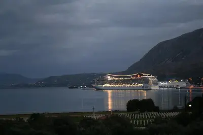 a large cruise ship in the water at night at Penthhouse Studio next to the beach in Souda