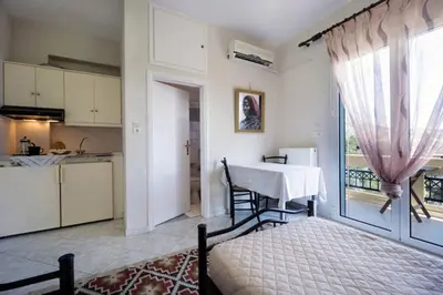 a living room with a table and a kitchen with a window at Penthhouse Studio next to the beach in Souda