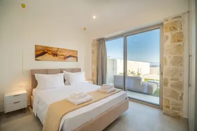 a bedroom with a bed and a large window at Fantasea Villas, villa Lux in Galangádhos