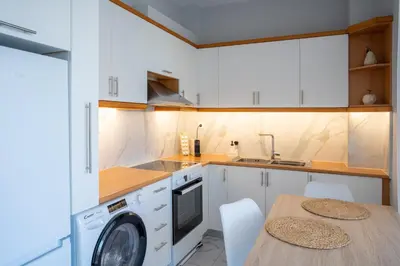 a kitchen with a washing machine and a table at Tessera Alfa city apartment in Chania Town