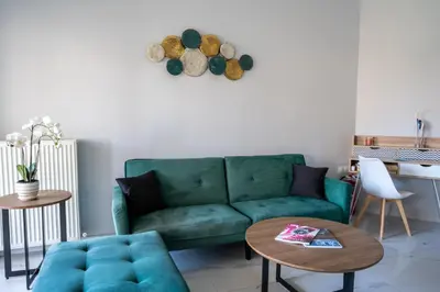 a living room with a green couch and a table at Tessera Alfa city apartment in Chania Town