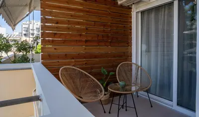 a patio with two chairs and a table on a balcony at Tessera Alfa city apartment in Chania Town
