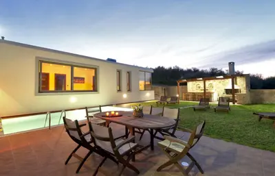 a patio with a wooden table and chairs at Modern Interior Villa in Chania Town