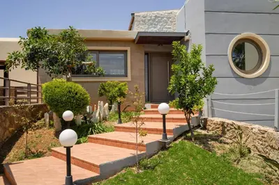 a house with a garden with stairs and trees at Modern Interior Villa in Chania Town
