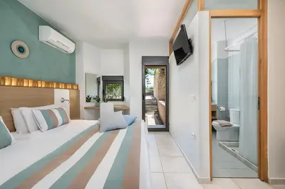a bedroom with a large white bed and a television at Villa AnnaNiko, Luxury Villa, 2 Heated Pools, Jacuzzi, Gym, Stunning Views, Green Energy in Gerani Chanion