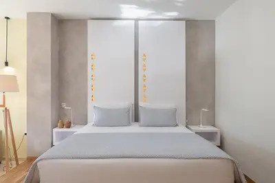 a bedroom with a large white bed with two blue pillows at Villa AnnaNiko, Luxury Villa, 2 Heated Pools, Jacuzzi, Gym, Stunning Views, Green Energy in Gerani Chanion