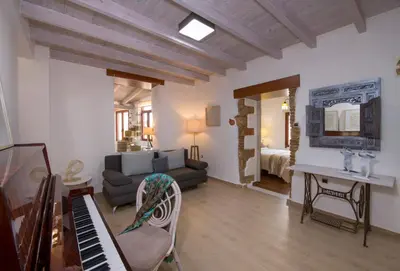 a living room with a couch and a piano at Villa Splantzia - Heated pool - Garden in Chania Town