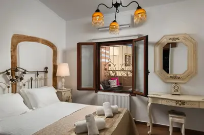 a bedroom with a bed and a table and a mirror at Villa Splantzia - Heated pool - Garden in Chania Town