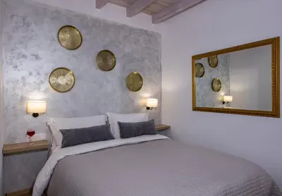 a bedroom with a bed and a mirror on the wall at Villa Splantzia - Heated pool - Garden in Chania Town