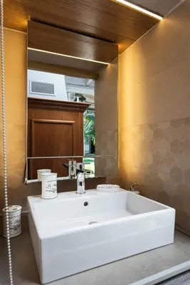 a bathroom with a white sink and a mirror at Villa Splantzia - Heated pool - Garden in Chania Town