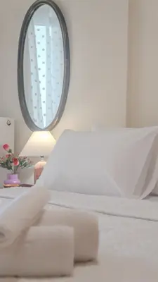 a bedroom with a white bed and a mirror at Melina's House in Chania Town