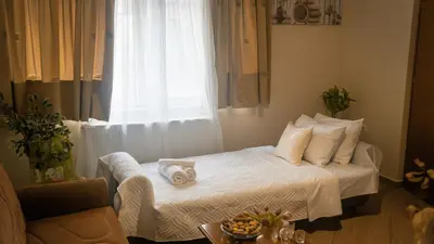 a bedroom with a white bed with a window at Melina's House in Chania Town