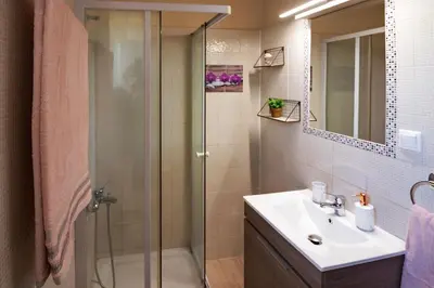 a bathroom with a glass shower and a sink at Beautiful Villa in Zounákion