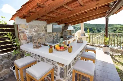 an outdoor kitchen with a table and stools at Beautiful Villa in Zounákion