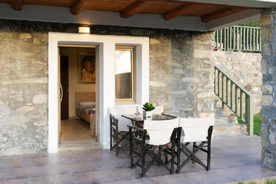 a patio with a table and chairs on a stone wall at Beautiful Villa in Zounákion