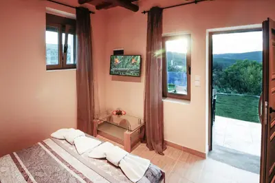 a bedroom with a bed and a large window at Beautiful Villa in Zounákion