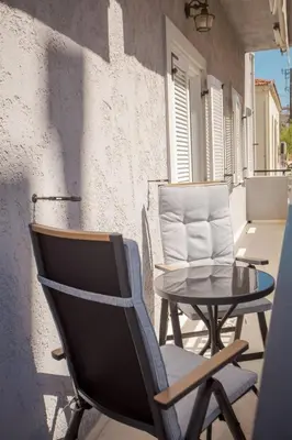 a patio with two chairs and a table and a building at The White Marble Luxury City Apt in Chania Town