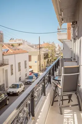 a chair on a balcony overlooking a city street at The White Marble Luxury City Apt in Chania Town