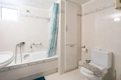 a bathroom with a tub and a toilet and a sink at The White Marble Luxury City Apt in Chania Town