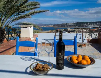 a bottle of wine and a bowl of fruit on a table at Venetian House in Chania Town