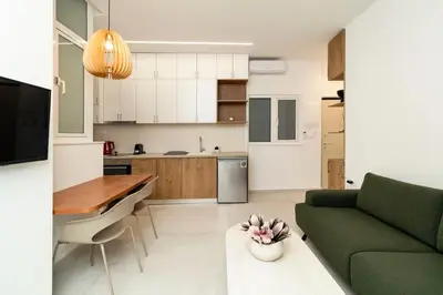 a kitchen and living room with a green couch and a table at Alma & Nina Apt in Chania Town