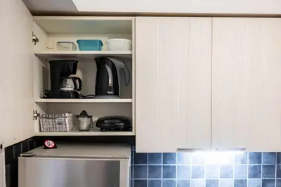 a kitchen with white cupboards and a stove at Kamari Petit Studio & Apartment - Chania in Chania Town