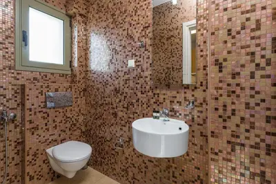a bathroom with a white sink and a toilet at Olive Chrysi Luxury Villa with in-room plunge pool in Chania Town