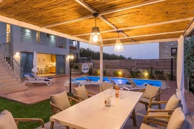 a patio with a table and chairs and a pool at Olive Chrysi Luxury Villa with in-room plunge pool in Chania Town
