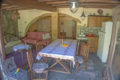 a kitchen with a table and chairs and a kitchen with a table and a refrigerator at Diving into silence - Traditional Stone House in Kakópetros