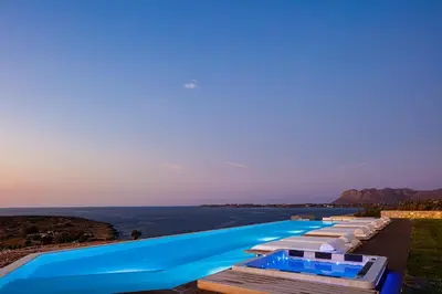 a row of swimming pools with the ocean in the background at Villa Mika in Chania Town