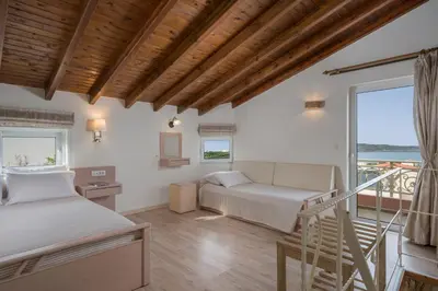 a living room with a bed and a balcony at Pantanassa Villas in Agia Marina Nea Kydonias