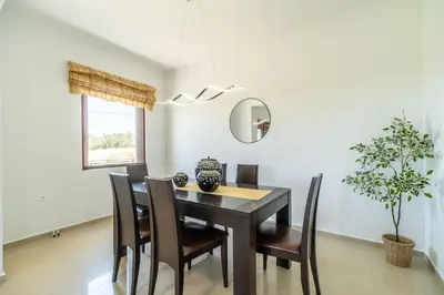 a dining room with a table and chairs and a mirror at Villa Aetheria by PosarelliVillas in Plátanos