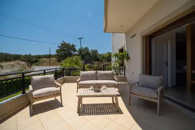 a patio with two chairs and a table on a balcony at Villa Aetheria by PosarelliVillas in Plátanos