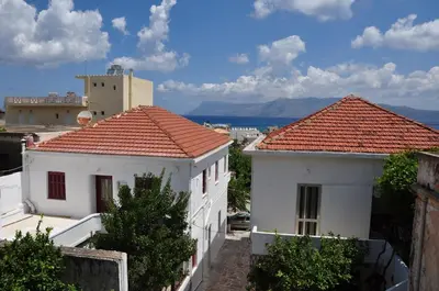 a view of two white buildings with red roofs at Three Bedroom Apartment in City Center with Sea View near the Beach in Kissamos