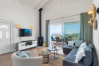 a living room with a couch and chairs and a tv at Villa Helissie in Vamos