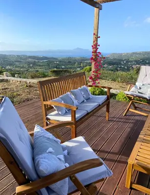 a wooden deck with two chairs and a table at Villa Helissie in Vamos