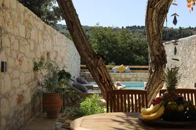a patio with a table with bananas on it at Tholos by Praxithea Stone House & Pool in Gavalochori