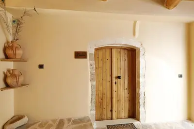 a wooden door in the corner of a room at Tholos by Praxithea Stone House & Pool in Gavalochori