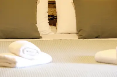 a white towel on a bed with pillows at Tholos by Praxithea Stone House & Pool in Gavalochori